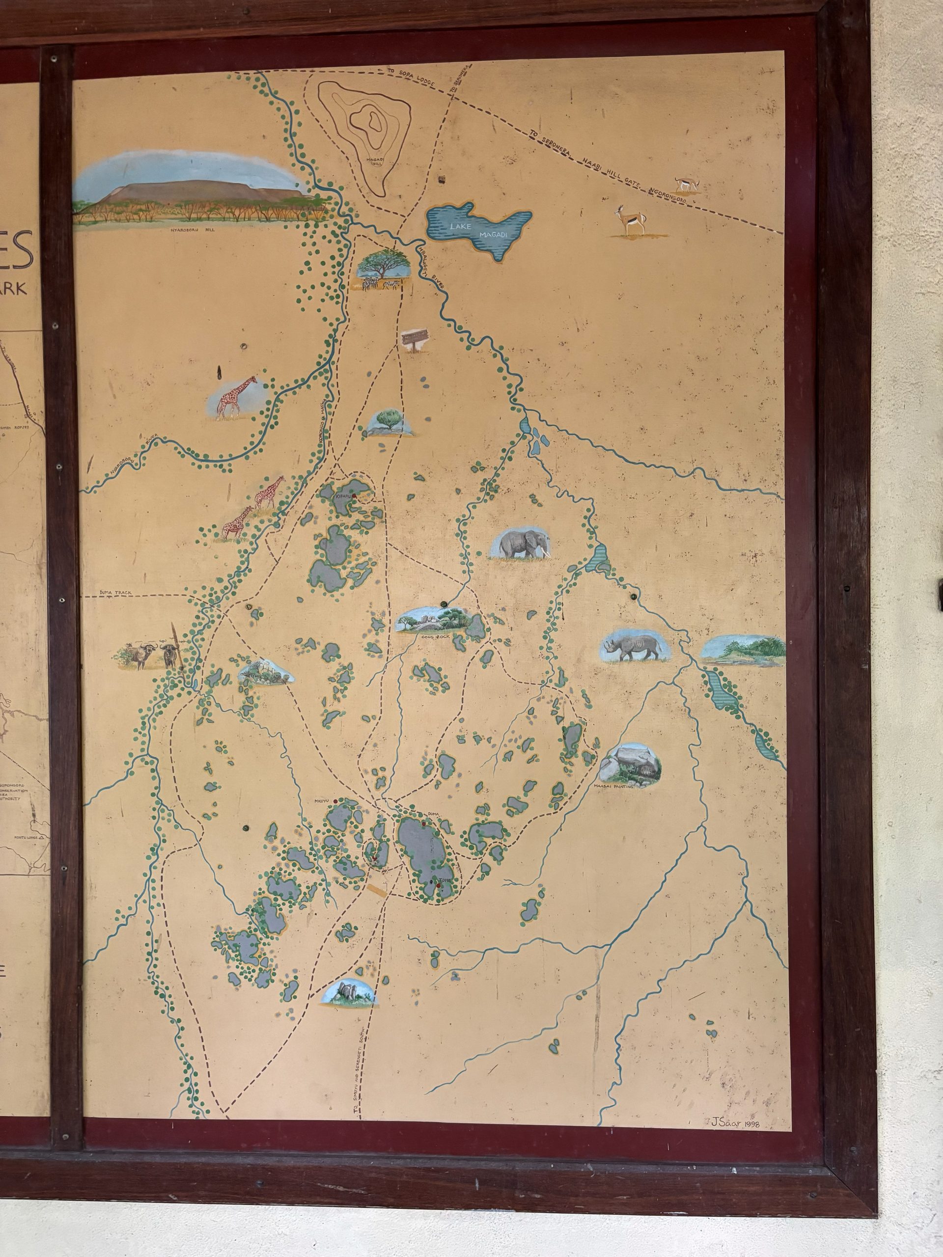 The hand-painted Moru Kopjes wildlife map — showing kopje clusters, game trails, Lake Magadi, and painted animal illustrations